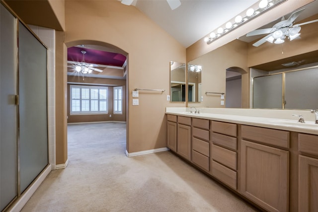 bathroom featuring a ceiling fan, a shower with shower door, vaulted ceiling, carpet flooring, and a sink