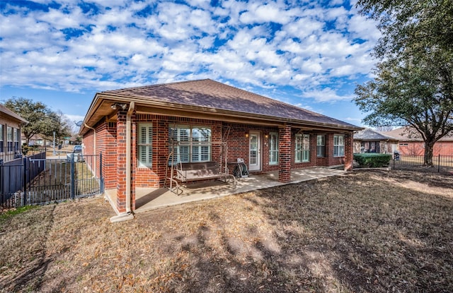 back of property featuring brick siding, a fenced backyard, and a patio