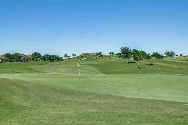 view of home's community featuring view of golf course and a lawn