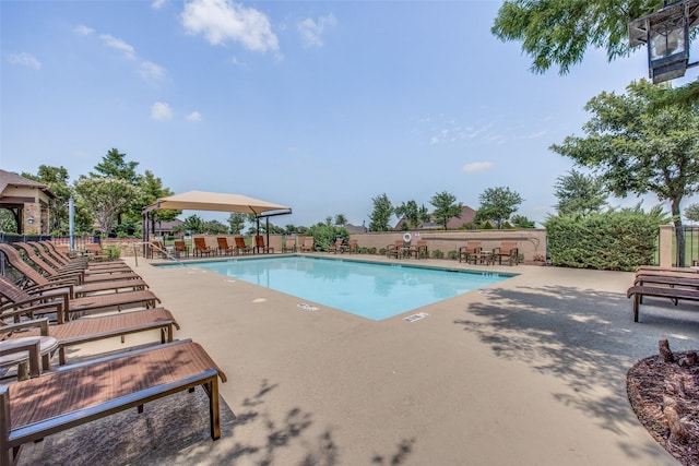 pool with fence and a patio