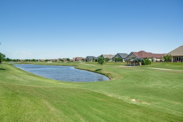 view of property's community with a water view, a residential view, and a yard