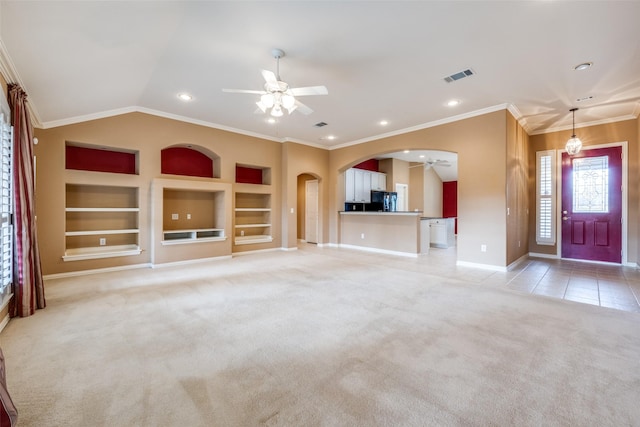 unfurnished living room with visible vents, arched walkways, a ceiling fan, built in features, and light colored carpet