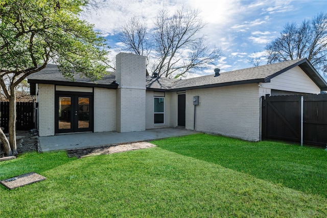 rear view of property with french doors, a yard, and a patio area