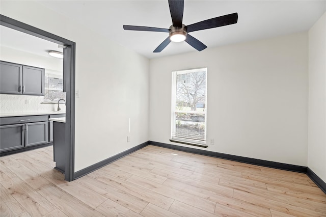 spare room with sink, ceiling fan, and light hardwood / wood-style flooring