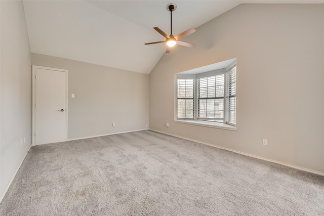 carpeted spare room with baseboards, ceiling fan, and vaulted ceiling