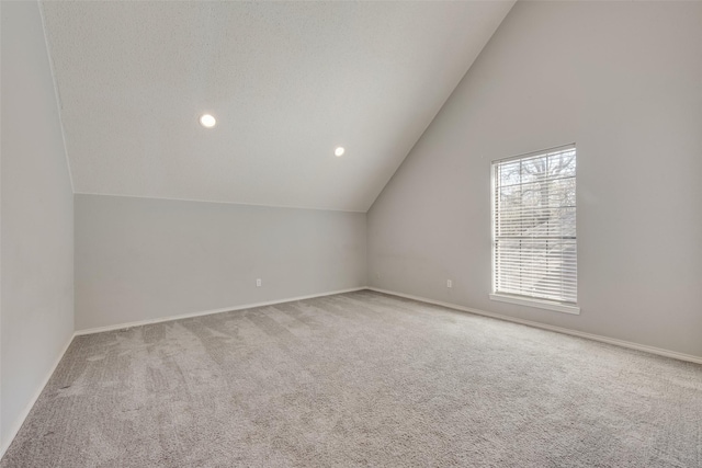 additional living space featuring baseboards, carpet flooring, lofted ceiling, and recessed lighting