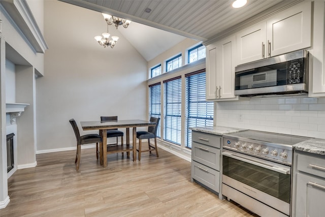 kitchen with appliances with stainless steel finishes, gray cabinetry, and light stone counters