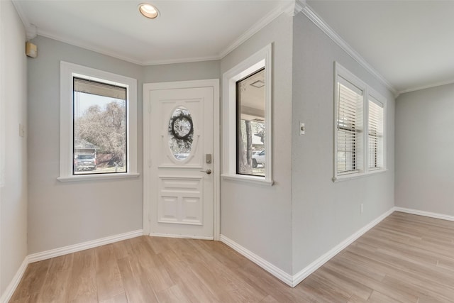 entryway featuring crown molding, baseboards, and light wood finished floors