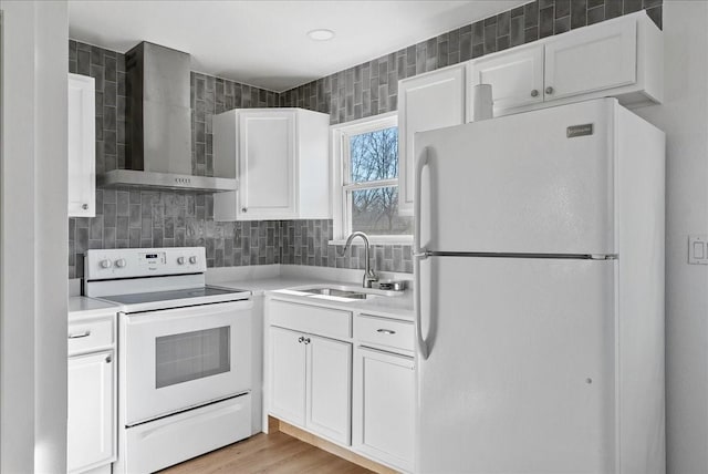 kitchen with sink, white appliances, white cabinetry, light hardwood / wood-style floors, and wall chimney exhaust hood