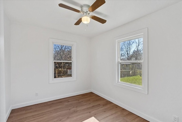 spare room featuring hardwood / wood-style flooring, ceiling fan, and a wealth of natural light