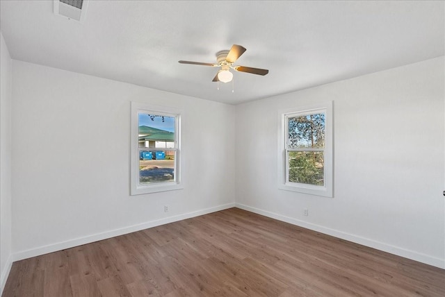 spare room with plenty of natural light, hardwood / wood-style floors, and ceiling fan