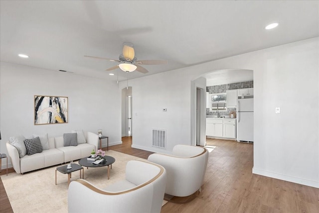 living room featuring ceiling fan and light wood-type flooring