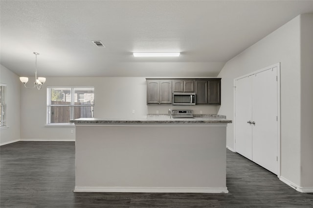 kitchen with dark brown cabinets, stainless steel appliances, decorative light fixtures, an inviting chandelier, and a center island