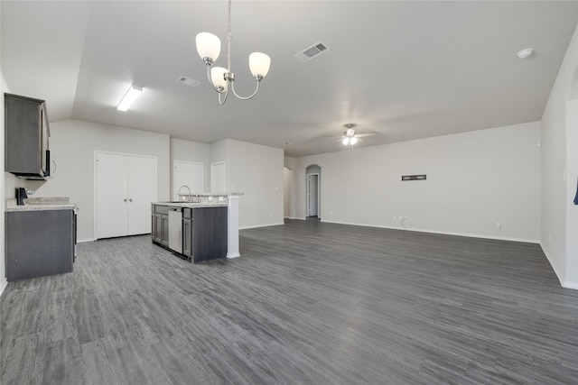 unfurnished living room with ceiling fan with notable chandelier, vaulted ceiling, dark wood-type flooring, and sink