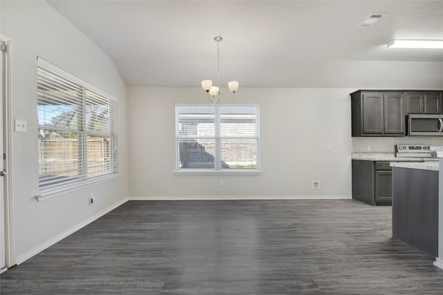 kitchen with lofted ceiling, dark brown cabinets, appliances with stainless steel finishes, dark hardwood / wood-style floors, and pendant lighting