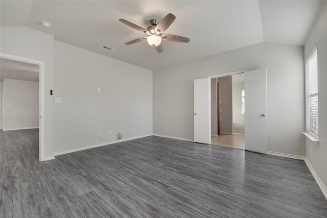 empty room featuring ceiling fan, dark hardwood / wood-style floors, and vaulted ceiling