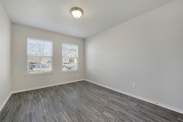 unfurnished room with dark hardwood / wood-style flooring