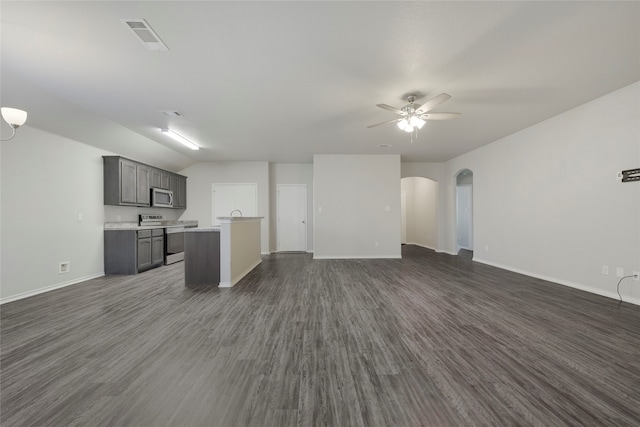 unfurnished living room featuring ceiling fan, dark wood-type flooring, and vaulted ceiling