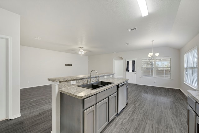 kitchen with pendant lighting, dishwasher, a kitchen island with sink, sink, and vaulted ceiling