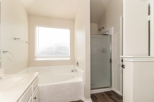 bathroom with vanity, plus walk in shower, hardwood / wood-style floors, and a textured ceiling