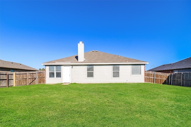 rear view of property with a yard