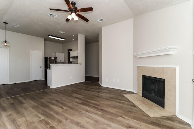 unfurnished living room featuring dark hardwood / wood-style flooring, a fireplace, and ceiling fan