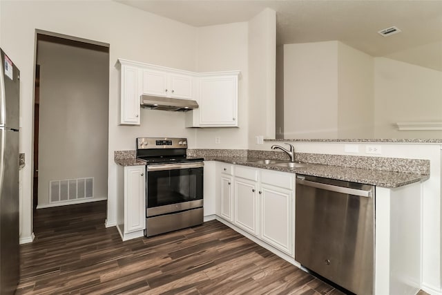 kitchen featuring white cabinetry, appliances with stainless steel finishes, dark hardwood / wood-style flooring, and dark stone counters