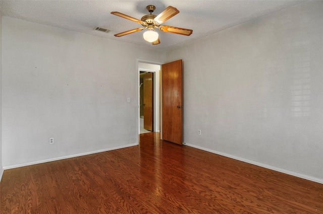 spare room featuring a textured ceiling, ceiling fan, and dark wood-type flooring