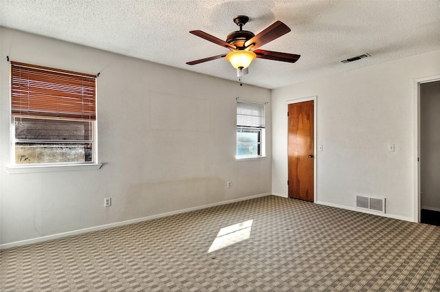 spare room with carpet, a textured ceiling, and ceiling fan