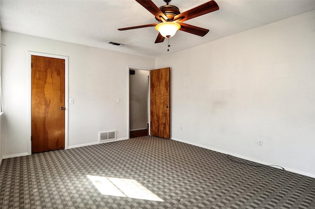 unfurnished room with ceiling fan and a textured ceiling