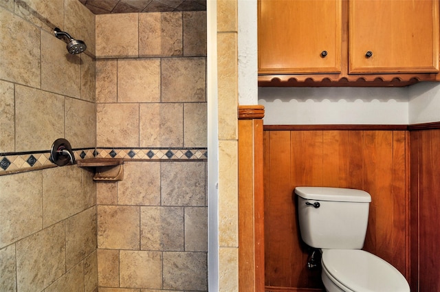 bathroom with a tile shower and toilet