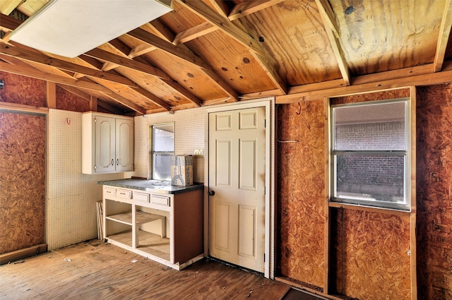 kitchen with light wood-type flooring, white cabinetry, and vaulted ceiling