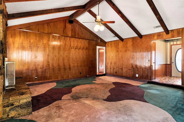 unfurnished living room with vaulted ceiling with beams, carpet floors, ceiling fan, and wood walls