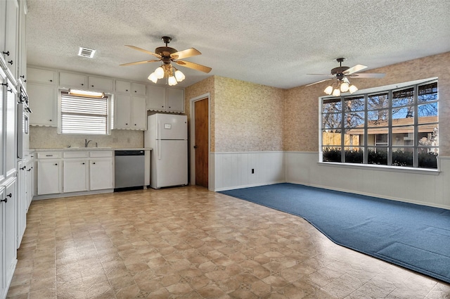 kitchen with white refrigerator, dishwasher, sink, and white cabinets