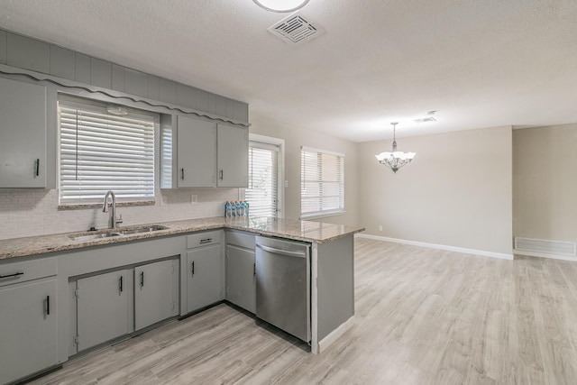 kitchen with gray cabinets, pendant lighting, sink, stainless steel dishwasher, and light wood-type flooring