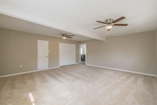 carpeted empty room featuring ceiling fan and beamed ceiling