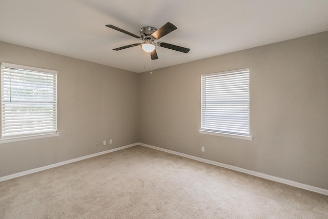 carpeted spare room with ceiling fan