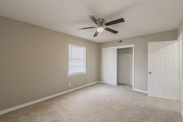 unfurnished bedroom with ceiling fan, a closet, and light carpet