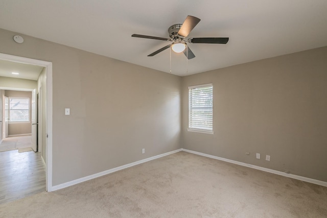 carpeted empty room with ceiling fan and a healthy amount of sunlight