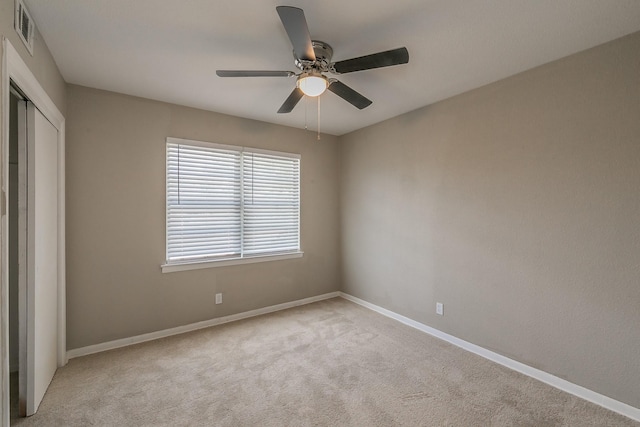 unfurnished bedroom with ceiling fan, light colored carpet, and a closet