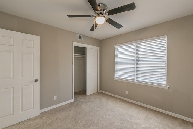 unfurnished bedroom with ceiling fan, a closet, and light carpet