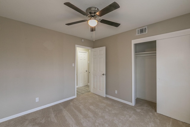 unfurnished bedroom featuring light colored carpet, ceiling fan, and a closet