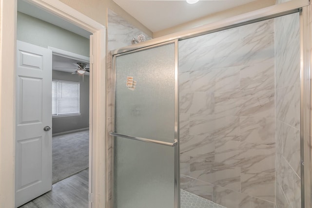 bathroom featuring ceiling fan and a shower with shower door