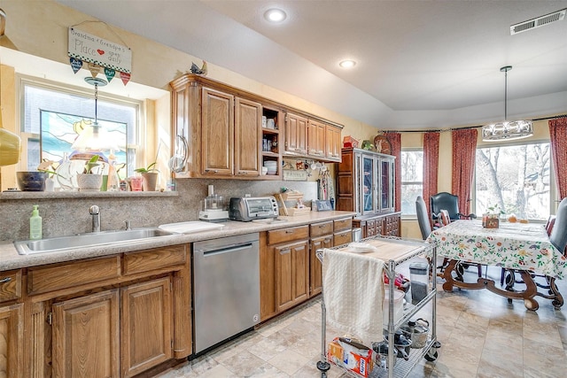 kitchen featuring stainless steel dishwasher, decorative light fixtures, lofted ceiling, and sink