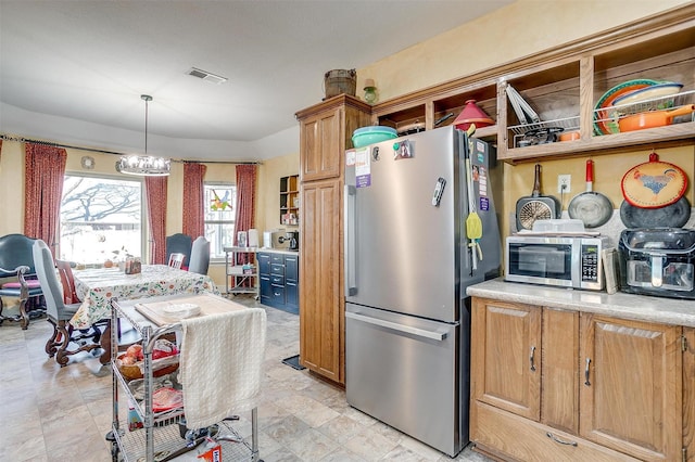 kitchen featuring a chandelier, decorative light fixtures, and stainless steel appliances