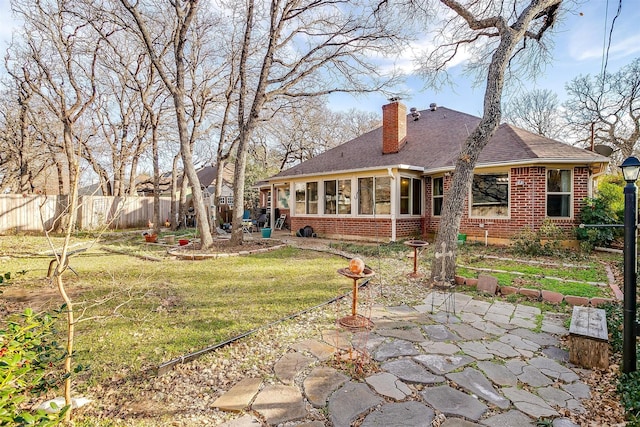 back of house with a lawn, a patio area, and a sunroom