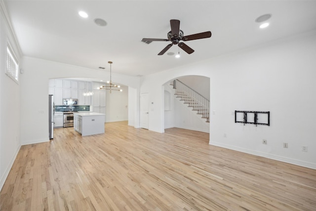 unfurnished living room featuring crown molding, light hardwood / wood-style flooring, and ceiling fan with notable chandelier