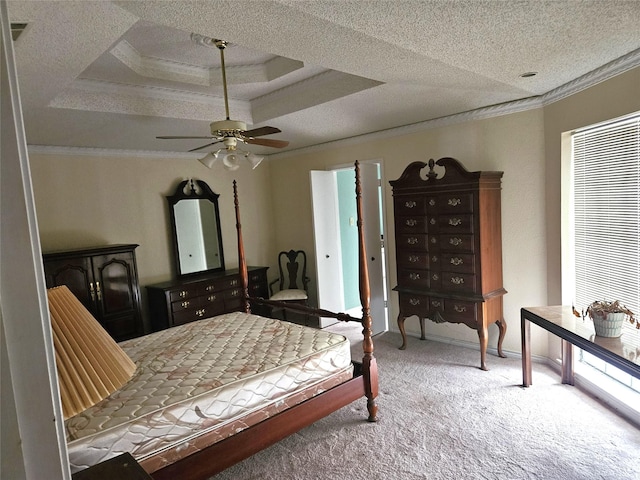 bedroom featuring a tray ceiling, ceiling fan, ornamental molding, and light colored carpet