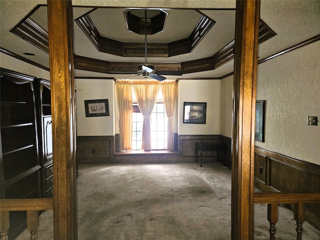 interior space with a tray ceiling and crown molding