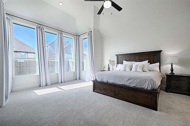 bedroom featuring ceiling fan, light colored carpet, multiple windows, and lofted ceiling